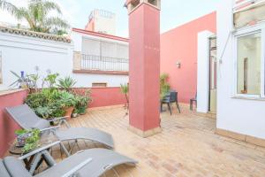 eine Terrasse mit Stühlen und Pflanzen auf einem Gebäude in der Unterkunft Casa Sevillana in Sevilla