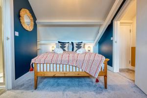 um quarto com uma cama com paredes azuis em Ashcroft Loft by Apricity Property - Stunning 3 Bedroom, 2 bathrooms, Cosy Central Apartment with balcony em Cirencester