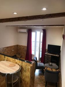 Una sala de estar con un escritorio, una mesa y sillas. en New Boat, en Narbona