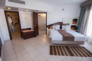 a bedroom with a large bed and a bathroom at Sharming Inn Hotels - Couples and Families Only in Sharm El Sheikh