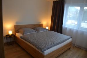 ein Schlafzimmer mit einem Bett mit zwei Kissen und einem Fenster in der Unterkunft Bungalow in Liptovský Ján