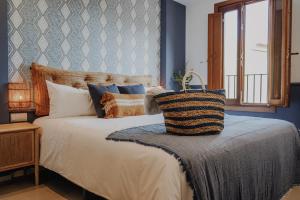 1 dormitorio con cama con almohadas y ventana en Casa Los Yayos by Nomad Stays, en Altea