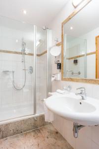 a white bathroom with a sink and a shower at HENRI Country House Seefeld in Seefeld in Tirol