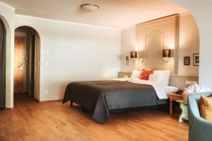 una camera d'albergo con letto e sedia di HENRI Country House Seefeld a Seefeld in Tirol