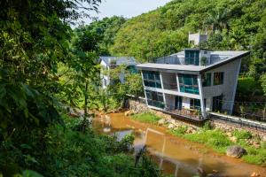 a house in the middle of a river at Les Bois BaVi by HOLO Serviced HomeStay in Hanoi
