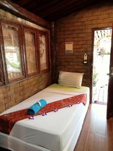 a bedroom with two beds in a brick wall at P P Garden Home Bungalow in Phi Phi Don