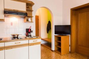 een keuken met witte kasten en een tv op een aanrecht bij Ferienwohnung Lanz 1 in Lana