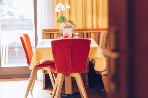 une table avec des chaises et un vase avec des fleurs. dans l'établissement Ferienwohnung Lanz 2, à Lana