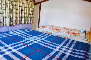 a bedroom with a bed with a blue and white blanket at Casa Com Quatro Dormitórios Pertinho Do Mar Em Capão Da Canoa in Capão da Canoa