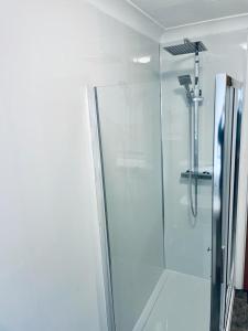 a shower with a glass door in a bathroom at Modern 2 Bedroom Apartment With Free Parking in Glasgow