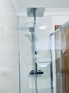 a shower with a glass door in a bathroom at Modern 2 Bedroom Apartment With Free Parking in Glasgow