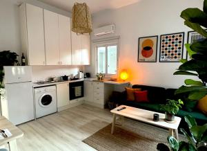 eine Küche und ein Wohnzimmer mit einem Sofa und einem Tisch in der Unterkunft Central Ground Floor Apartment in Nikosia