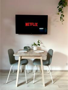 einen Tisch mit Stühlen und einen TV an der Wand in der Unterkunft Central Ground Floor Apartment in Nikosia