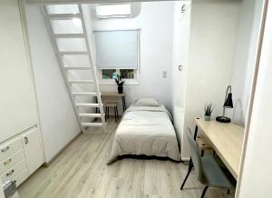 1 dormitorio con cama, escritorio y escalera en Central Ground Floor Apartment en Nicosia