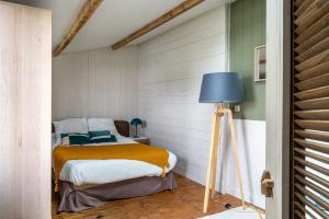 une chambre avec un lit et une lampe bleue dans l'établissement Maison pour 8 avec piscine - Noirmoutier-en-l'Île, à Noirmoutier-en-l'lle 17 autres photos