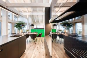 una cucina con tavoli e sedie in una stanza di Luxus Penthouse Zentral by A-Appartments a Brand