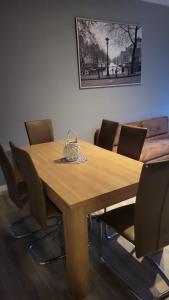 une table en bois avec des chaises et un panier sur le dessus dans l'établissement Flensburg Strandnah, à Flensbourg