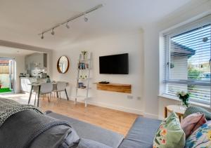 a living room with a couch and a tv on a wall at Pontcanna Mews in Cardiff
