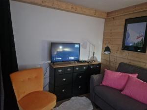 - un salon avec un canapé et une télévision sur une commode dans l'établissement La Duchère Le Plan La Giettaz, à La Giettaz