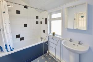 uma casa de banho branca com um lavatório e uma banheira e um lavatório. em Host & Stay - Holyrood Lodge em Bridlington