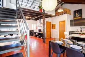 a kitchen and dining room with a staircase in a loft at Livemálaga Cervantes Attic & Terrace in Málaga