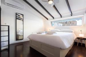 a white bedroom with a large bed and a window at Livemálaga Cervantes Attic & Terrace in Málaga