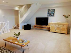 a large living room with a flat screen tv at Stunning Cottage on the Edge of the Cotswolds in Charfield