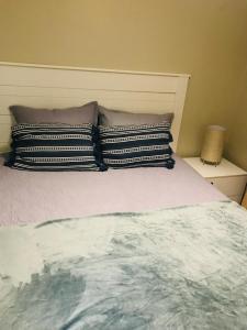 a bed with two pillows on top of it at Lancy Apartments in Gaborone