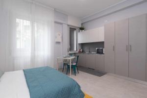 1 dormitorio con cama, mesa y cocina en Montalbino place, en Milán