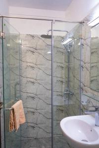 a bathroom with a glass shower and a sink at Vista Apartment Mariners Blue in Nuwara Eliya +28 photos
