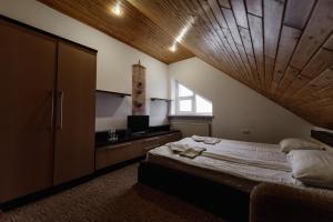 a bedroom with a large bed with a wooden ceiling at Готель Яблуниця in Yablunytsya