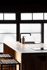 a kitchen with a sink and some windows at Maana Kamo in Kyoto