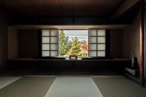 a room with a window with a view of a tree at Maana Kamo in Kyoto