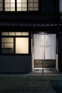 a building with two windows with lights in it at Maana Kamo in Kyoto
