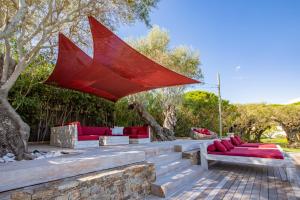 d'une terrasse dotée d'un mobilier rouge et d'un parasol rouge. dans l'établissement Vyylla Private Resort, à Saint-Tropez