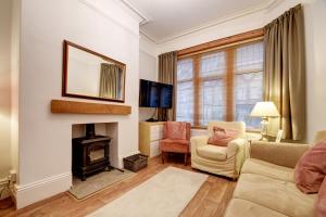 a living room with a couch and a fireplace at Spacious Victorian Townhouse near HCC with off street parking in Harrogate