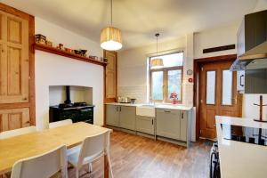 een keuken met een houten tafel en een eetkamer bij Spacious Victorian Townhouse near HCC with off street parking in Harrogate