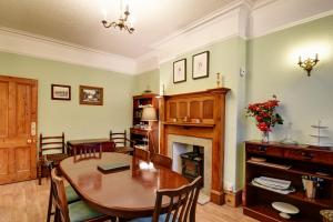 een eetkamer met een tafel en een open haard bij Spacious Victorian Townhouse near HCC with off street parking in Harrogate