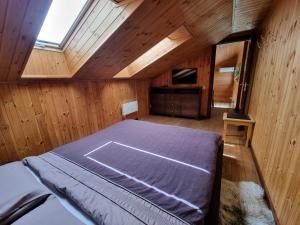 1 dormitorio con 1 cama en una habitación de madera en Saules Street Home en Kuldīga