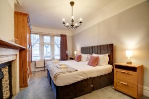 a bedroom with a large bed and a fireplace at Spacious Victorian Townhouse near HCC with off street parking in Harrogate