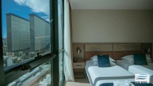 a hotel room with two beds and a window at New Wave Hotel in Batumi