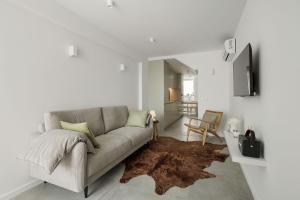 sala de estar con sofá y alfombra en Lapa 84 - seafront house, en Póvoa de Varzim