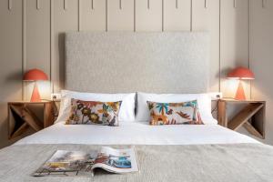 a bedroom with a white bed with two lamps at Magno Apartments Hernando Colón in Seville