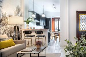 sala de estar y cocina con sofá y mesa en Magno Apartments Hernando Colón en Sevilla