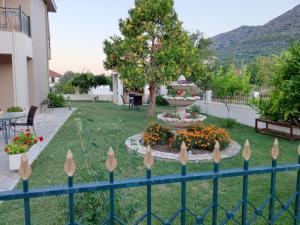 a fence with flowers and a fountain in a yard at ΔΙΑΜΈΡΙΣΜΑ ΜΕΝΤΗΣ in Igoumenitsa
