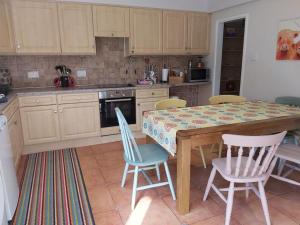 a kitchen with a table and chairs in it at Relaxing Retreat on the edge of the Cotswolds in Kingswood