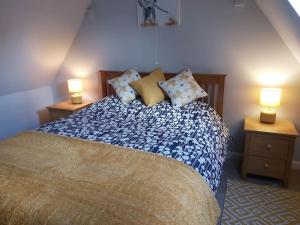 a bedroom with a bed with two lamps on tables at Relaxing Retreat on the edge of the Cotswolds in Kingswood