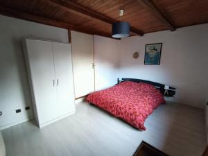 une chambre avec un lit avec une couette rouge dans l'établissement Appartement cozy 100m2 dans chalet savoyard, à Magland