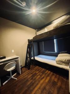 a dorm room with a bunk bed and a desk at SAMURISE Mt. Fuji in Fujikawaguchiko