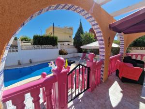 a house with a pink fence and a swimming pool at Villa pink Ambience in Mazarrón